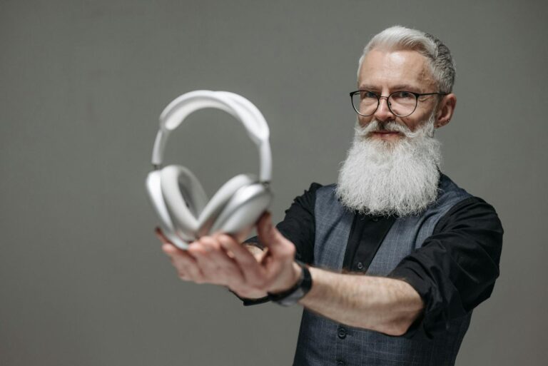 Starszy mężczyzna w okularach prezentuje airpods max